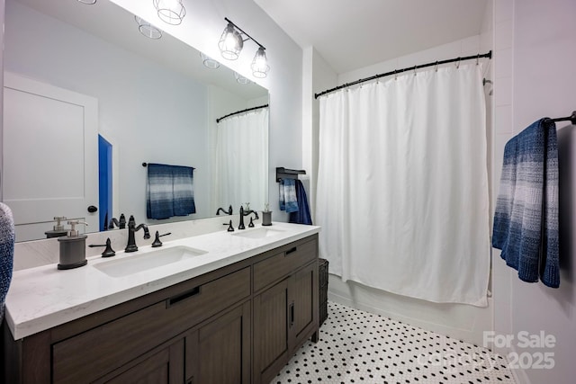 full bathroom with double vanity, shower / bath combo with shower curtain, a sink, and tile patterned floors