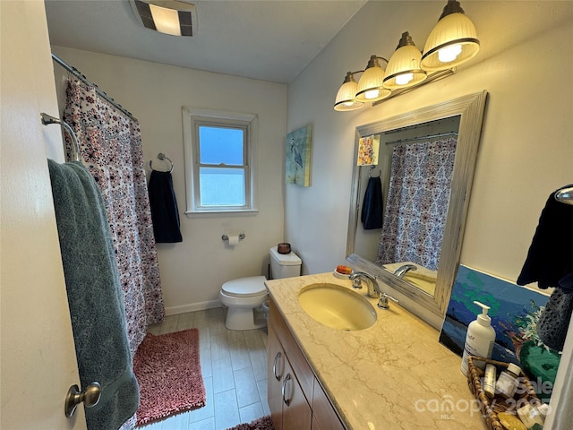 bathroom featuring toilet, baseboards, vanity, and a shower with curtain