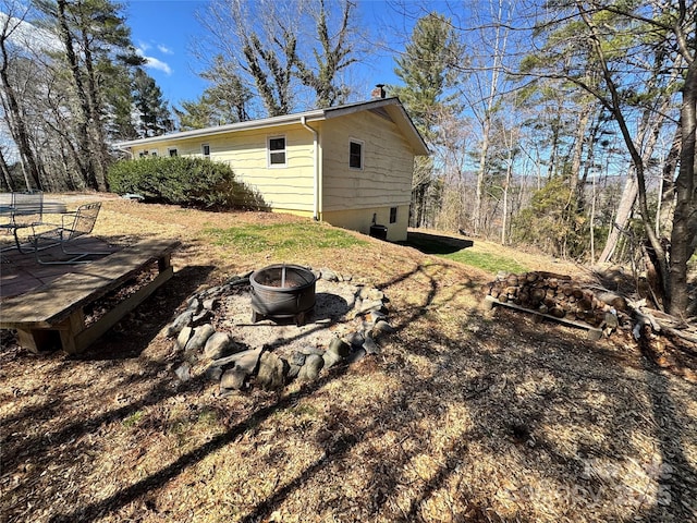 view of yard with a deck and a fire pit