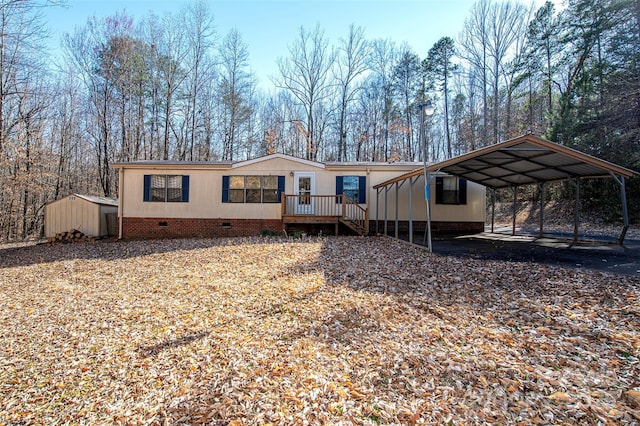 manufactured / mobile home with a deck, an outbuilding, a storage shed, crawl space, and a carport