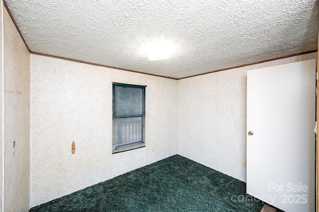 unfurnished room featuring a textured ceiling and dark carpet