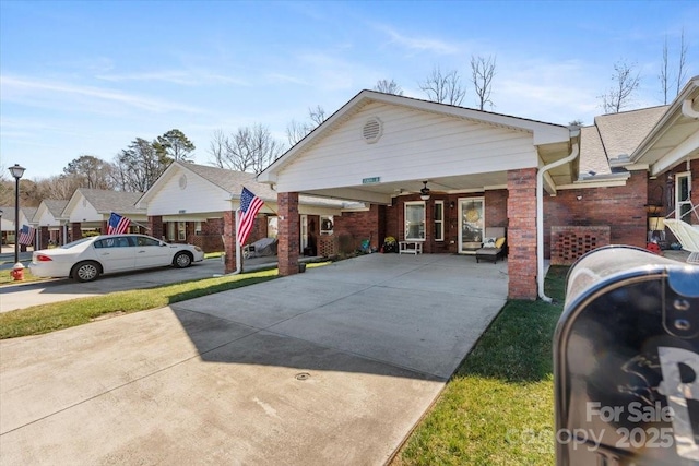 view of front of house featuring brick siding and concrete driveway