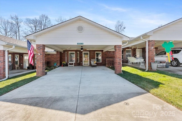 view of front of property featuring a ceiling fan, a front lawn, a carport, concrete driveway, and brick siding