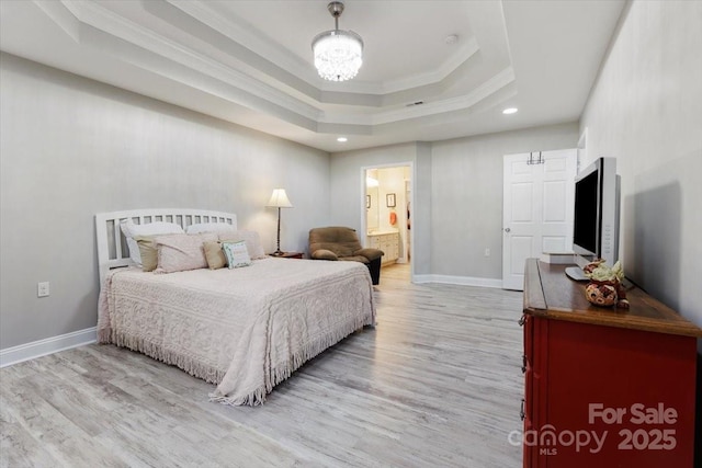 bedroom featuring a tray ceiling, baseboards, light wood-style flooring, and ornamental molding