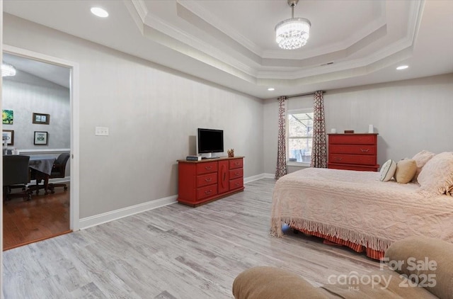 bedroom with a notable chandelier, baseboards, light wood-type flooring, and a tray ceiling