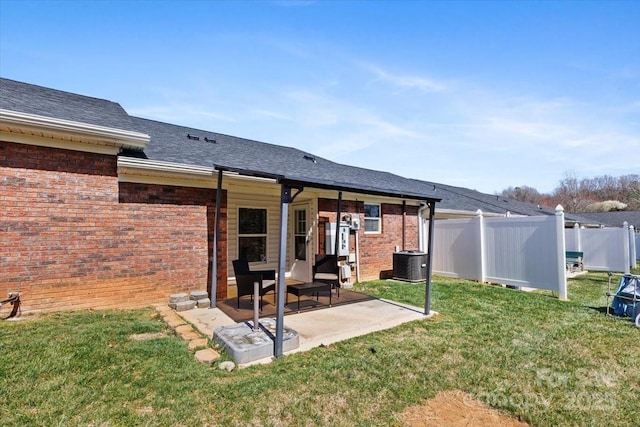 rear view of house featuring brick siding, central air condition unit, a patio area, and a yard