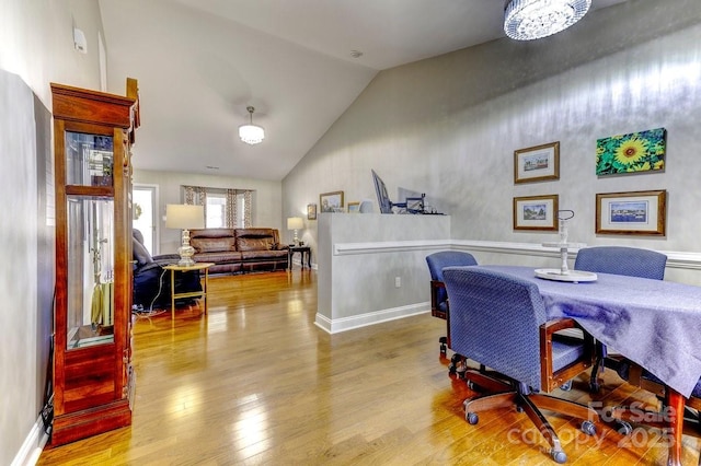 home office featuring high vaulted ceiling, baseboards, and wood finished floors