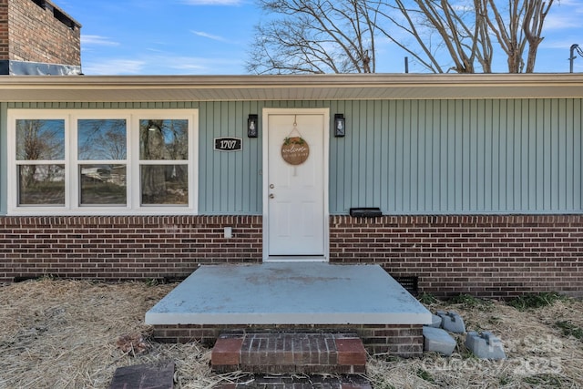 view of exterior entry with brick siding