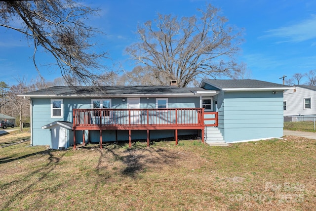 rear view of house with a yard and a wooden deck