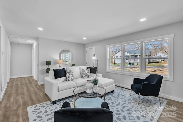 living room featuring baseboards, light wood finished floors, attic access, and recessed lighting