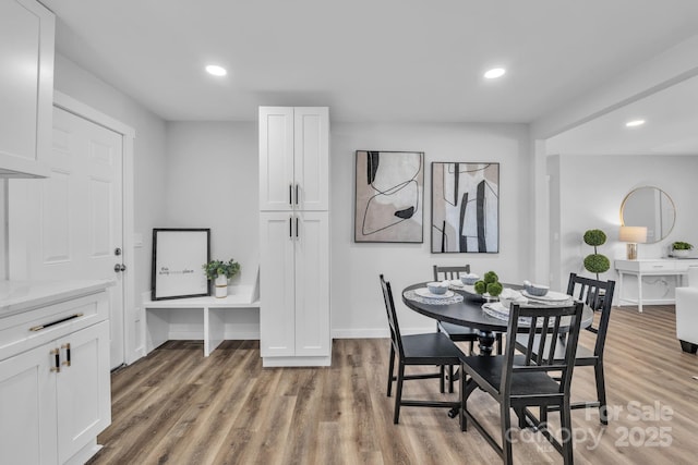 dining area featuring baseboards, wood finished floors, and recessed lighting