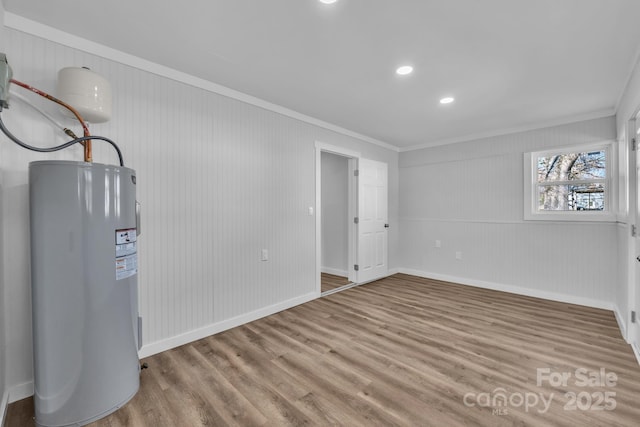 below grade area featuring water heater, light wood-style flooring, and baseboards