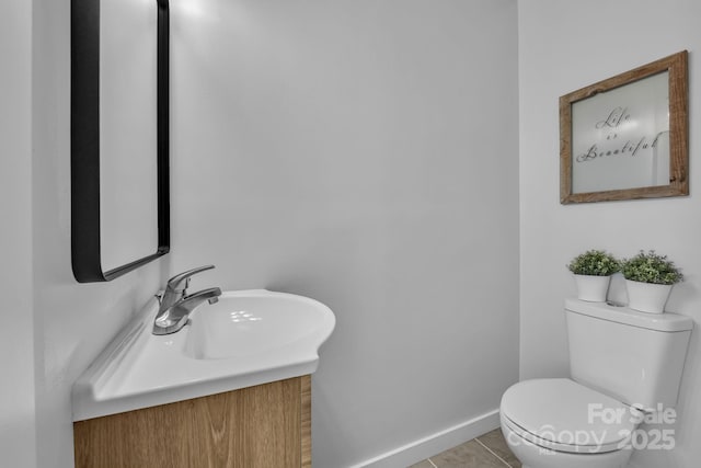 bathroom with toilet, tile patterned flooring, baseboards, and vanity