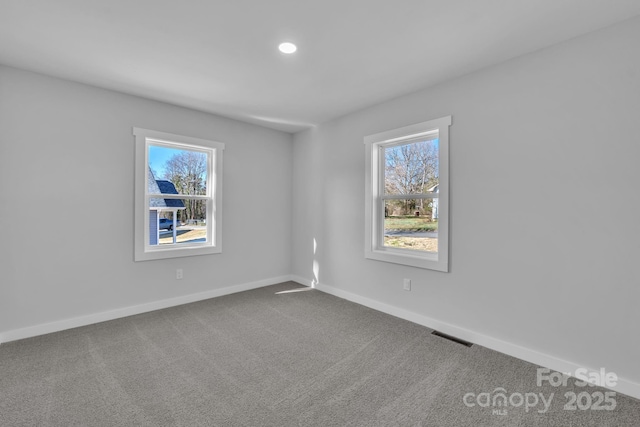 unfurnished room featuring carpet, a healthy amount of sunlight, and baseboards