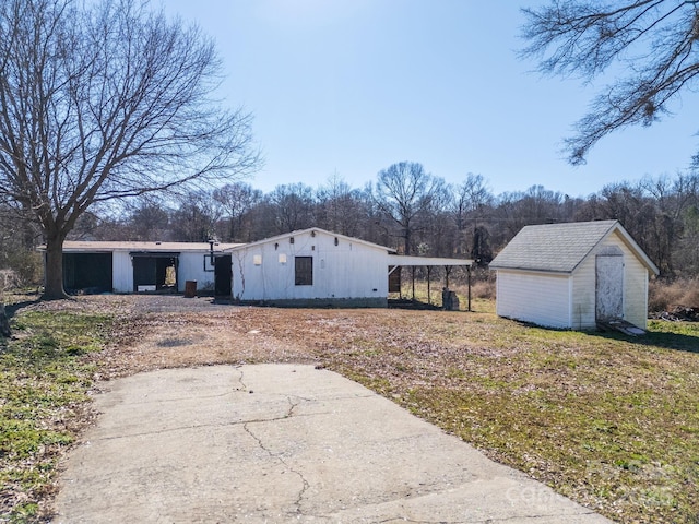 view of front of house with an outdoor structure, driveway, and a shed