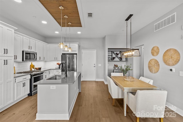 kitchen with visible vents, appliances with stainless steel finishes, decorative backsplash, and a sink