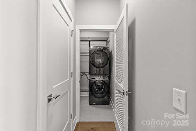 clothes washing area featuring laundry area and stacked washing maching and dryer