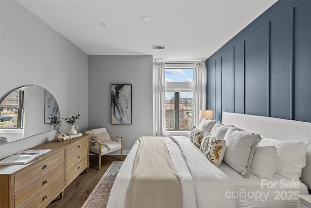 bedroom with dark wood-style flooring and visible vents