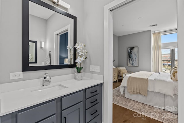 bathroom featuring vanity, wood finished floors, connected bathroom, and visible vents