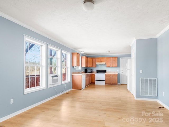 kitchen with light countertops, visible vents, light wood-style flooring, white appliances, and under cabinet range hood