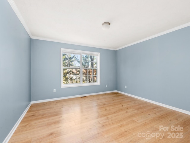 unfurnished room with ornamental molding, visible vents, light wood-style flooring, and baseboards