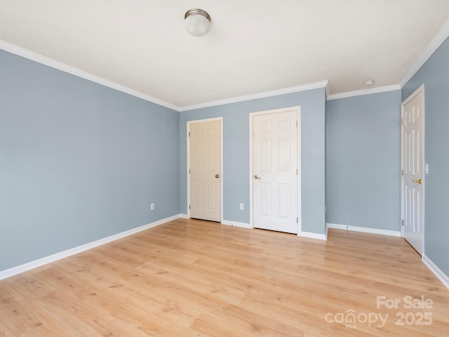 unfurnished bedroom with light wood-type flooring, crown molding, and baseboards