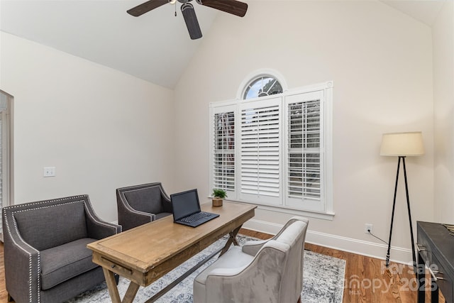 home office with high vaulted ceiling, wood finished floors, a ceiling fan, and baseboards