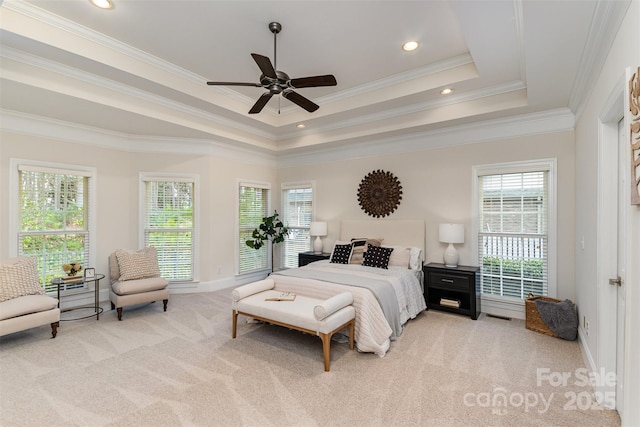 bedroom with light carpet, multiple windows, and a raised ceiling