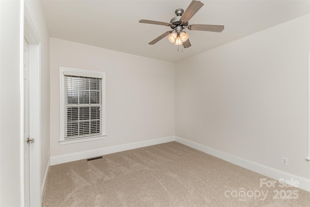 carpeted empty room featuring visible vents, baseboards, and a ceiling fan