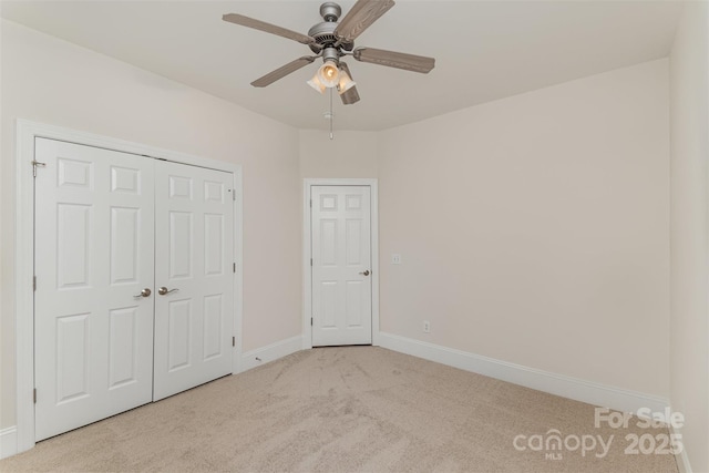 unfurnished bedroom with a ceiling fan, carpet, a closet, and baseboards