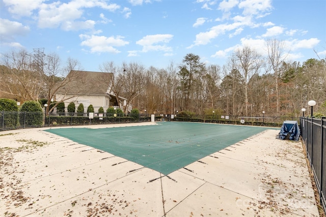 community pool with fence and a patio