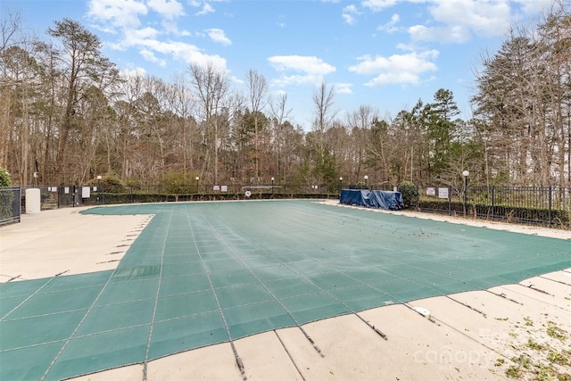 pool with a patio area and fence