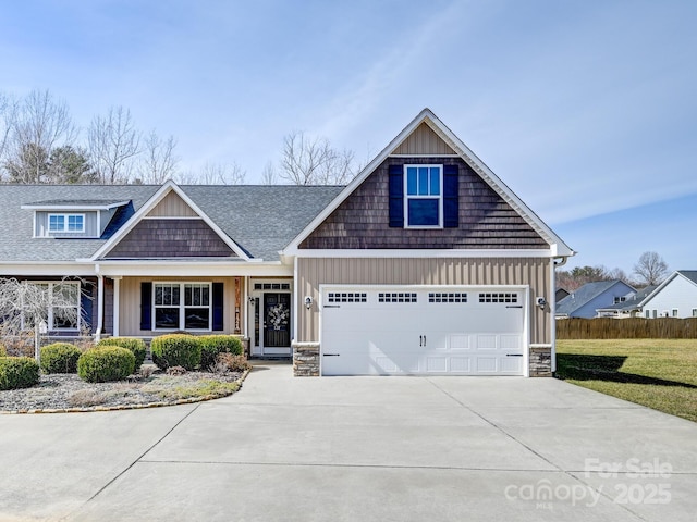 craftsman-style home with a garage, fence, concrete driveway, board and batten siding, and a front yard