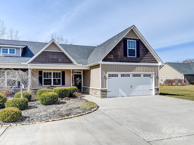 craftsman-style house with board and batten siding, a garage, stone siding, driveway, and a front lawn