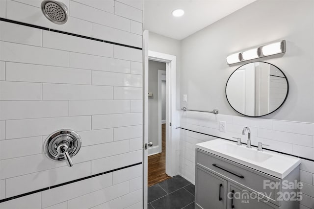 bathroom featuring tiled shower, tile patterned flooring, vanity, tile walls, and recessed lighting