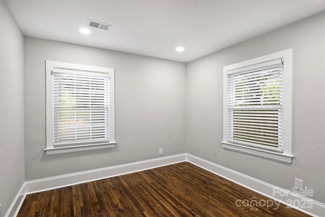 unfurnished room with recessed lighting, dark wood-style flooring, visible vents, and baseboards