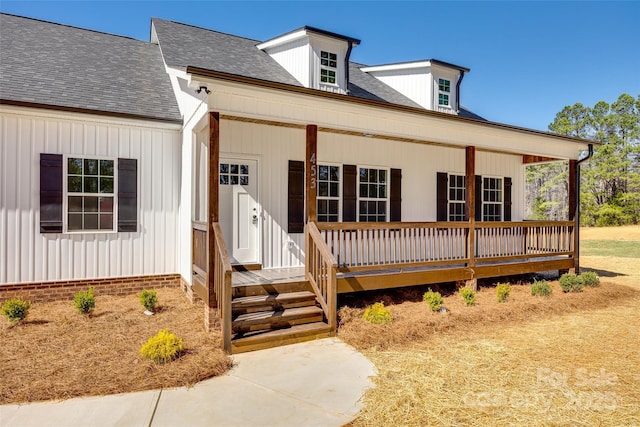 view of front facade with a porch, board and batten siding, and a shingled roof