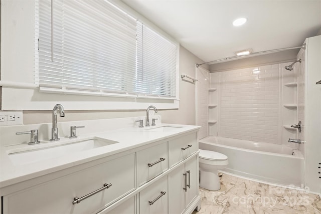 full bathroom featuring toilet, marble finish floor, bathtub / shower combination, and a sink