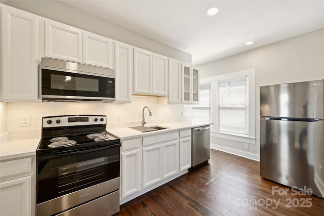 kitchen with decorative backsplash, appliances with stainless steel finishes, dark wood-style flooring, light countertops, and a sink