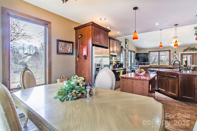 dining space with lofted ceiling, recessed lighting, and wood finished floors