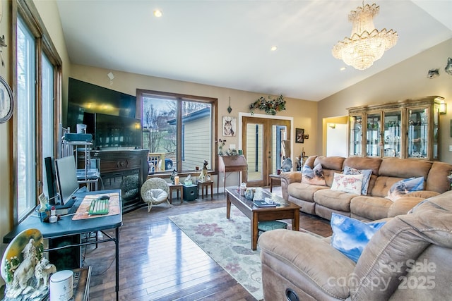 living room with a notable chandelier, recessed lighting, a glass covered fireplace, vaulted ceiling, and hardwood / wood-style flooring