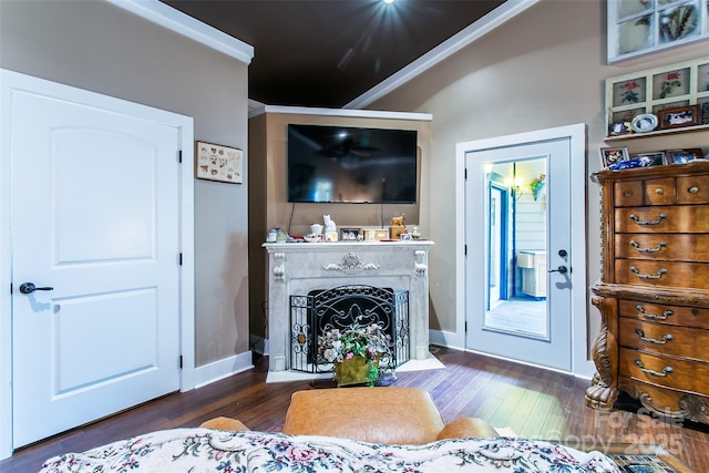 living area featuring baseboards, wood finished floors, a fireplace with flush hearth, and crown molding