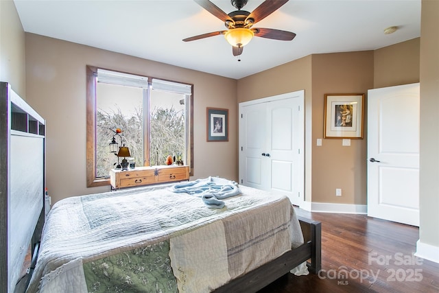 bedroom featuring ceiling fan, a closet, baseboards, and wood finished floors