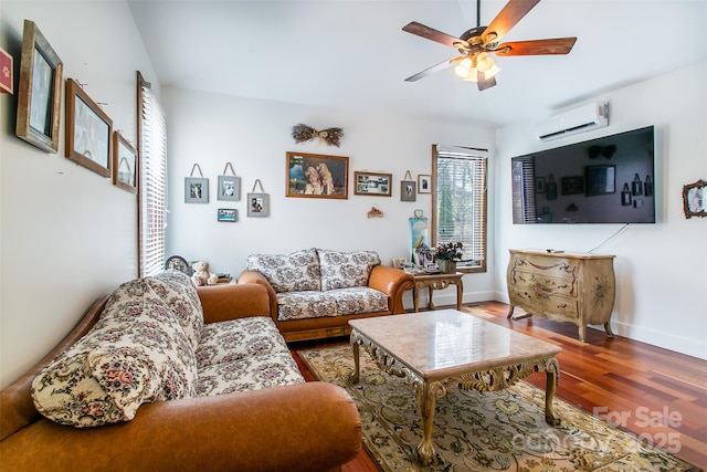 living area with baseboards, a ceiling fan, wood finished floors, and a wall mounted AC