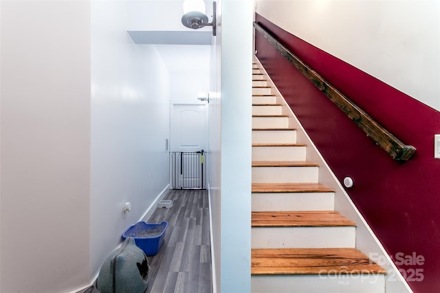 stairway with baseboards and wood finished floors