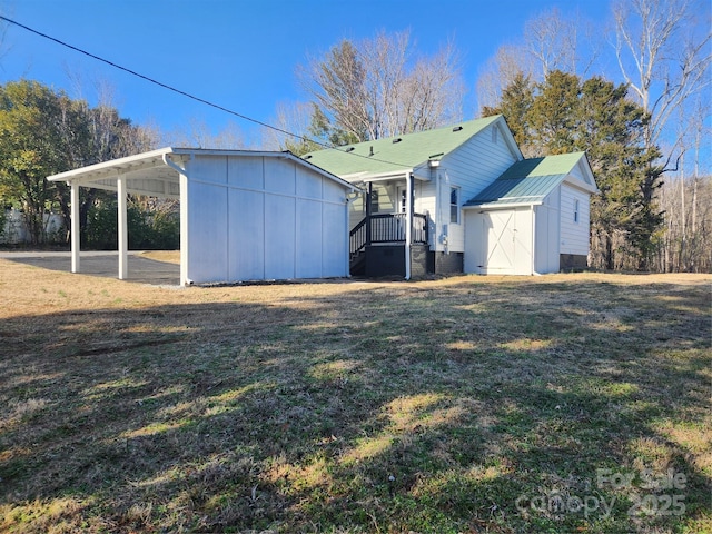 exterior space with a yard, metal roof, an outdoor structure, and a shed