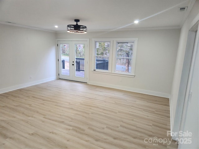 spare room featuring light wood-style floors, baseboards, and ornamental molding