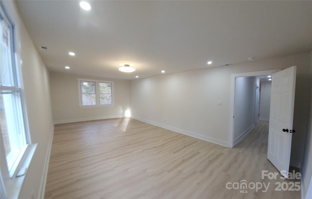 empty room featuring baseboards, light wood finished floors, visible vents, and recessed lighting