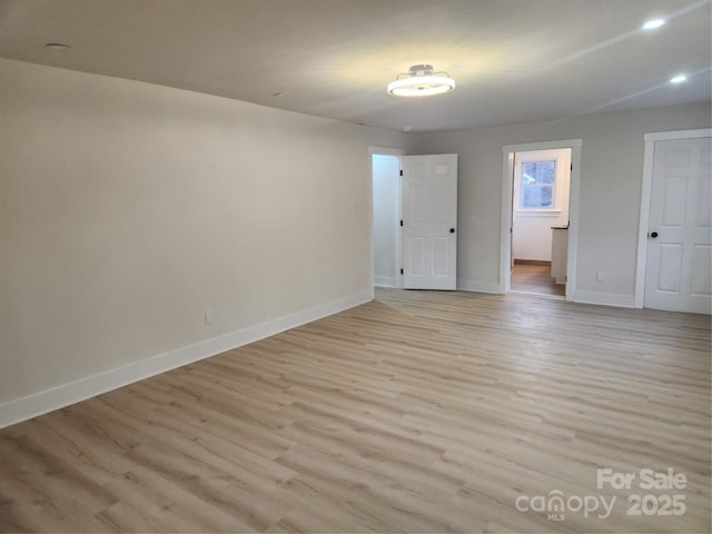 unfurnished room featuring light wood-type flooring and baseboards