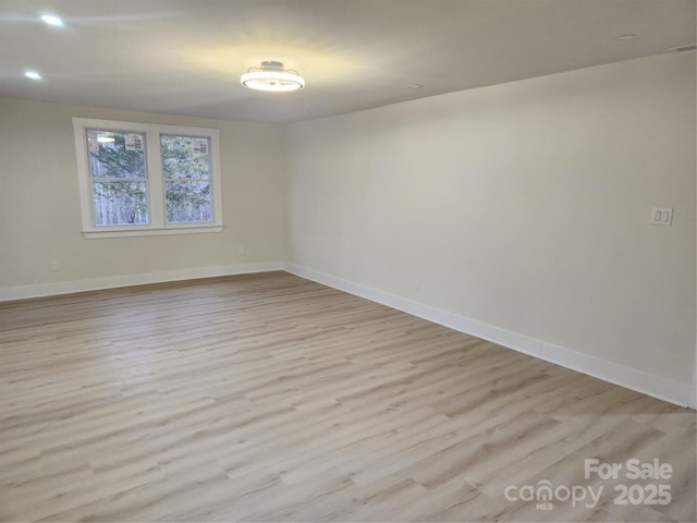 unfurnished room featuring recessed lighting, light wood-type flooring, and baseboards